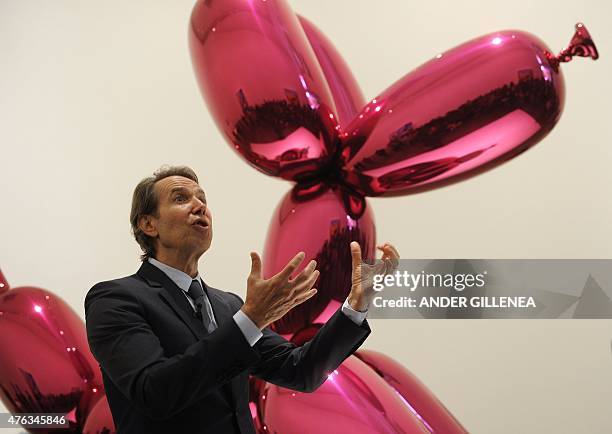 Artist Jeff Koons gestures past one of his piece of art during the presentation of the "Jeff Koons: Retrospective" exhibition at the Guggenheim...