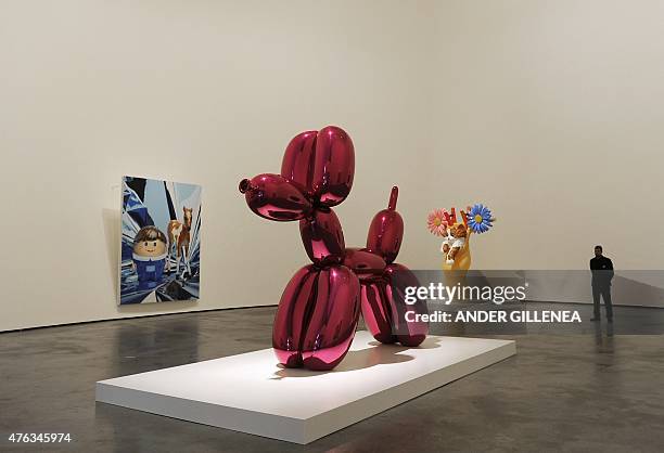 Man stands past pieces of art by US artist Jeff Koons during the presentation of the "Jeff Koons: Retrospective" exhibition at the Guggenheim Bilbao...