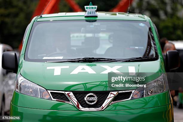 Nissan Motor Co. NV200 Taxi cab for the Tokyo Musen business cooperative sits parked below the Tokyo Tower during a launch event in Tokyo, Japan, on...