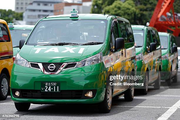 Nissan Motor Co. NV200 Taxi cabs for the Tokyo Musen business cooperative sit parked below the Tokyo Tower during a launch event in Tokyo, Japan, on...