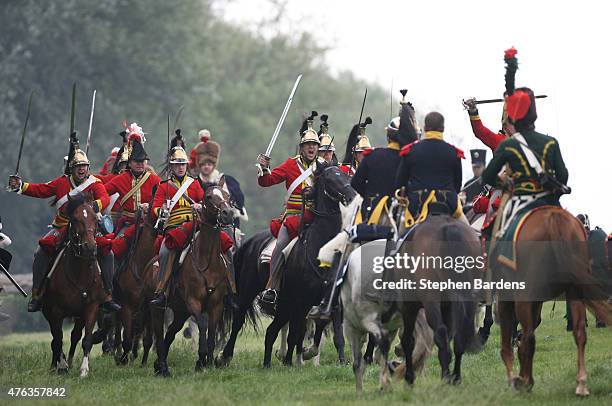 Historical re-enactors dressed as British heavy cavalry participate in a cavalry charge during a Battle of Waterloo re-enactment on June 17, 2007 in...