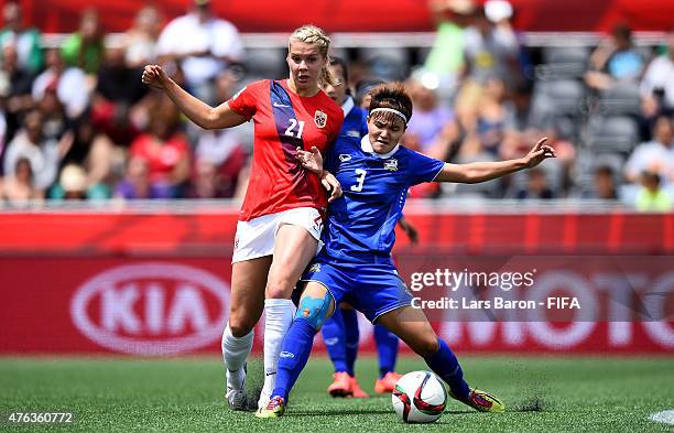 Ada Hegerberg of Norway is challenged by Natthakarn Chinwong of Thailand during the FIFA Women's World Cup 2015 Group B match between Norway and...