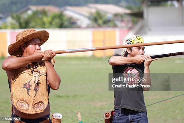 Participants were competing in a Sumpit tournament, during the Gawai Dayak Naik Dango. Sumpit is a traditional weapon of the Dayak in Kalimantan.