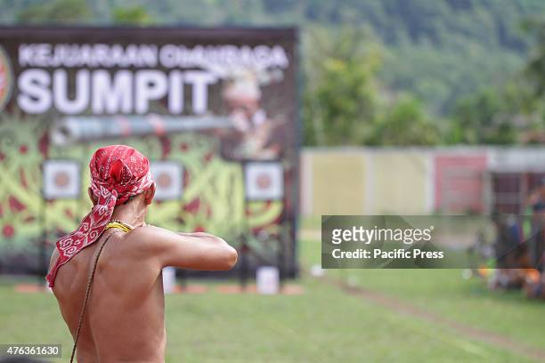 Participants were competing in a Sumpit tournament, during the Gawai Dayak Naik Dango. Sumpit is a traditional weapon of the Dayak in Kalimantan.