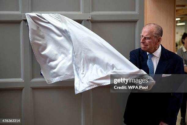 Prince Philip, Duke of Edinburgh, pulls the curtain to unveil a plaque at the end of his visit to Richmond Adult Community College in Richmond on...