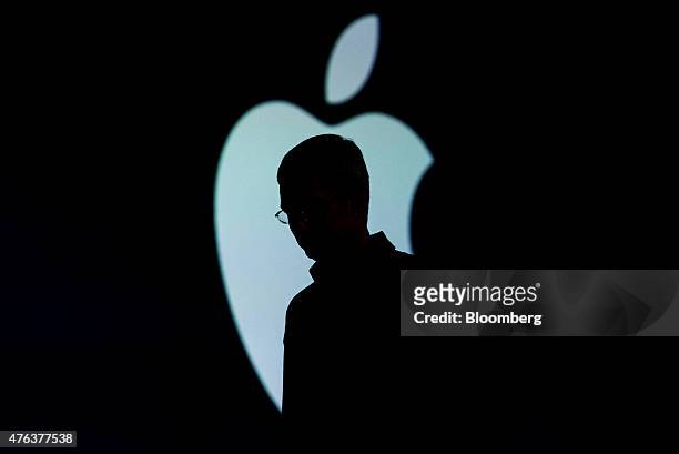 The silhouette of Tim Cook, chief executive officer of Apple Inc., is seen as he exits the stage during the Apple World Wide Developers Conference in...