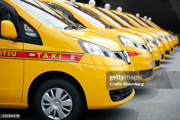Nissan Motor Co. NV200 Taxi cabs including one for Nihon Kotsu Co., left, sit in a parking lot during a launch event in Tokyo, Japan, on Monday, June...