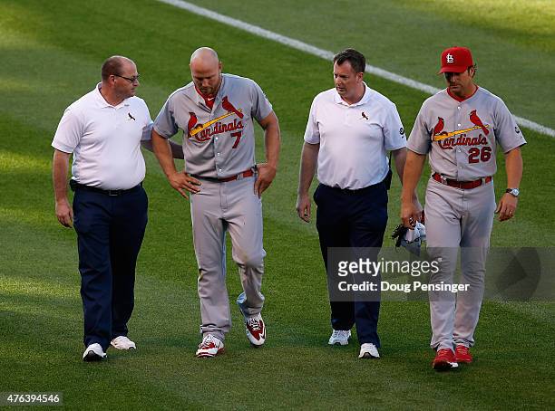 Leftfielder Matt Holliday of the St. Louis Cardinals is escorted off the field by manager Mike Matheny of the St. Louis Cardinals and the trainers...