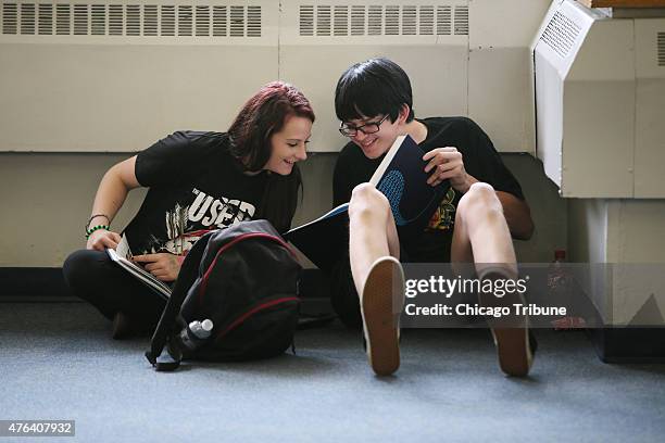 Freshman Caitlin Smith and David Wohlgemuth, right, react as they look through their new yearbooks at Prospect High School on May 26, 2015 in Mt....