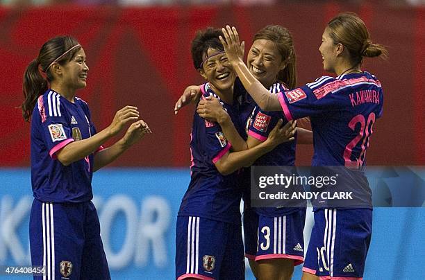 Japan defender Saori Ariyosho embraces Azusa Iwashimizu as teammates Nahomi Kawasumi and Yuri Kawamuraas celebrate their win over Switzerland during...