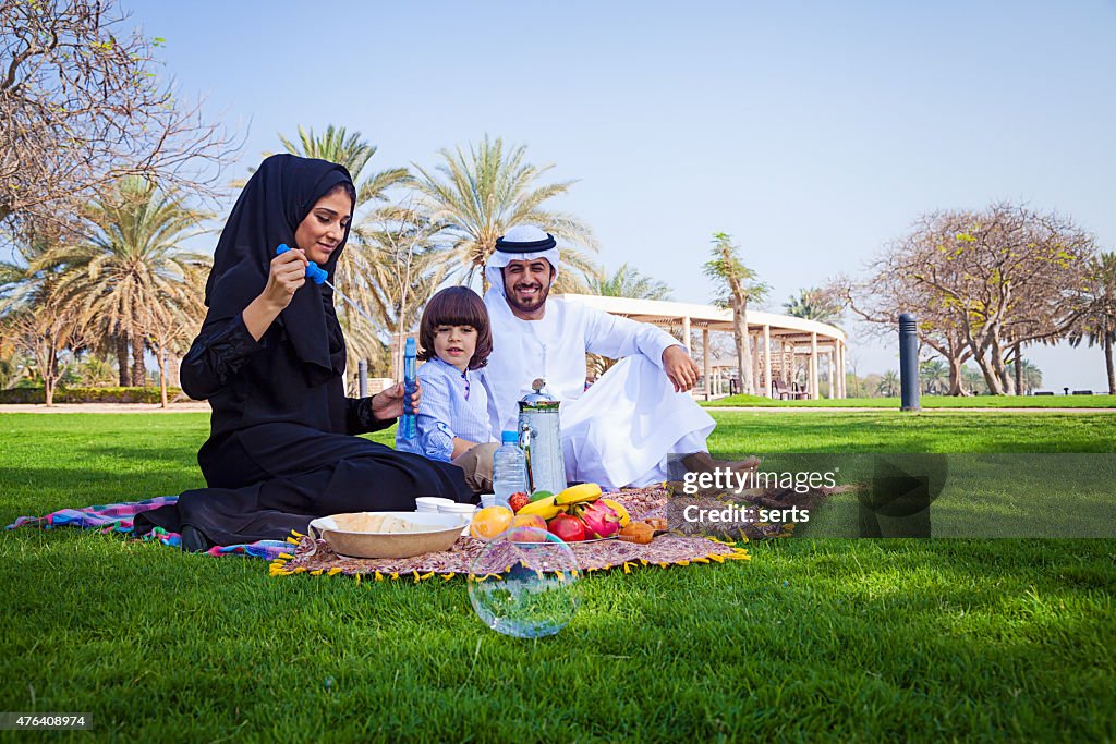 Traditional Young Arabic family having picnic at park