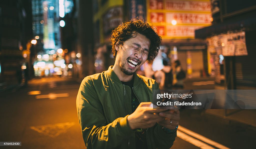 Young japanese man texting on the phone