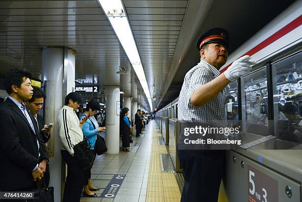 Takashi Arai, a Tokyo Metro Co. Employee, gestures as he works on a platform of the Marunouchi subway line, operated by Tokyo Metro Co., during the...