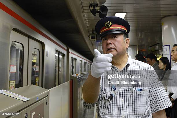 Takashi Arai, a Tokyo Metro Co. Employee, gestures as a train departs on the Marunouchi subway line, operated by Tokyo Metro Co., during the morning...