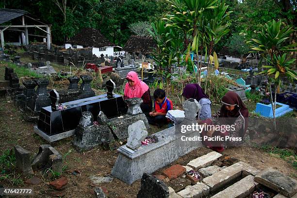 Residents pray at the tombs of their ancestors during Nyadran ritual in Sewu Cemetery. Nyadran ritual is a tradition to clean up and pray to their...