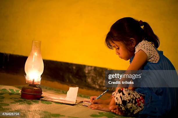 rural girl studying in lantern - indian school kids stockfoto's en -beelden