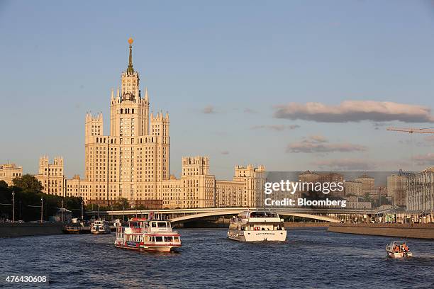 Cruise boats sail along the Moscow river near the Kotelnicheskaya embankment building, left, in Moscow, Russia, on Monday, June 8, 2015. Rents in...