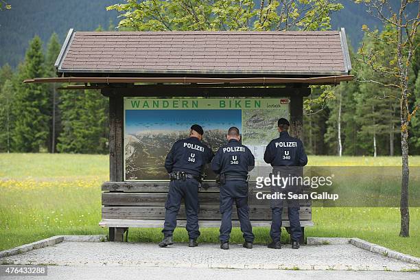 Austrian policemen look at a hiker's map near a police checkpoint on a road leading to the Interalpen-Hotel Tirol, venue of the upcoming Bilderberg...