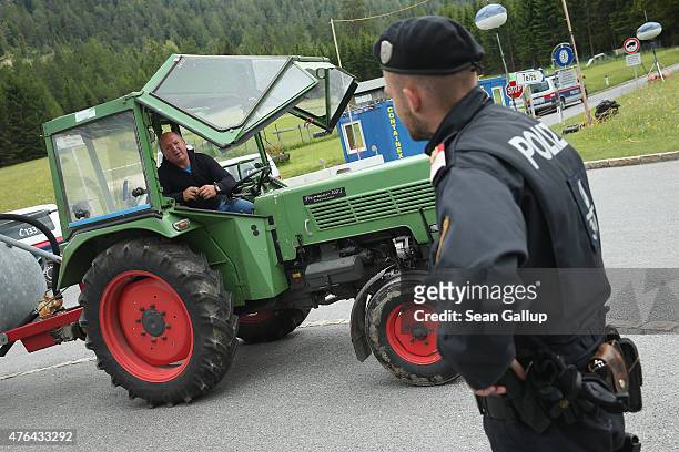 An Austrian policeman chats with a local farmer at a police checkpoint on a road leading to the Interalpen-Hotel Tirol, venue of the upcoming...