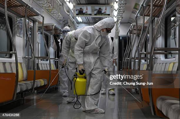 Disinfection workers wearing protective gears spray anti-septic solution in an subway amid rising public concerns over the spread of MERS virus at...