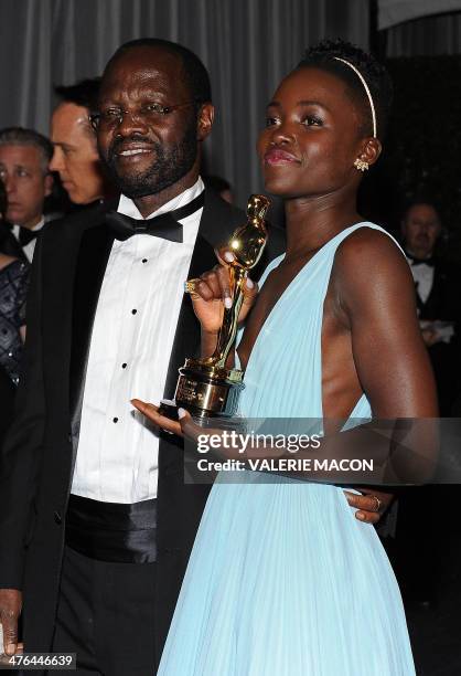 Winner for Best Supporting Actress in "12 Years a Slave" Lupita Nyong'o, flanked by her dad Peter Anyang' Nyong'o, poses with her trophy at the...