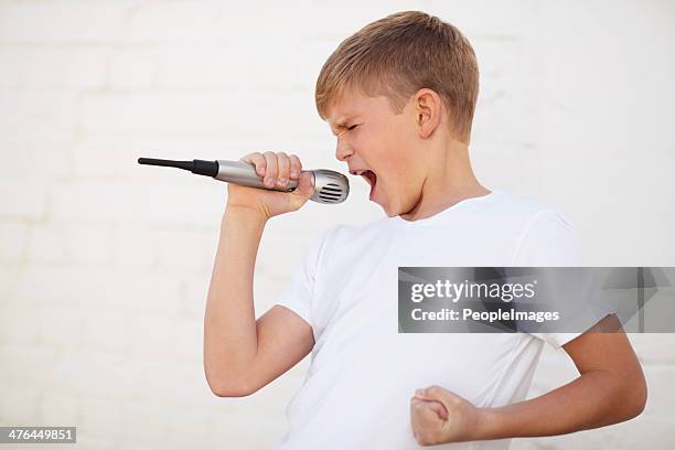 singing with conviction - boy singing stock pictures, royalty-free photos & images