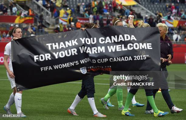 England's players carry a banner thanking the host country at the end of a Group F match at the 2015 FIFA Women's World Cup between France and...