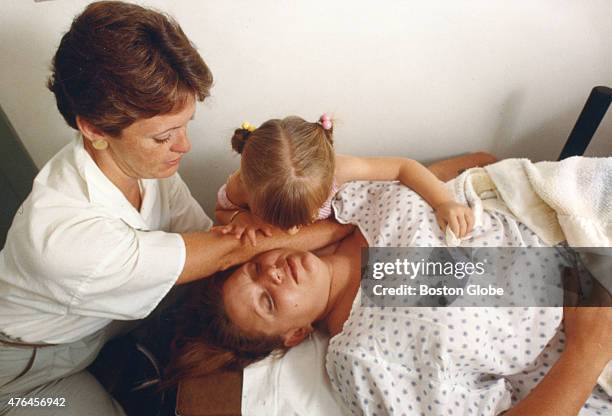 Former glass cutter Conny Burke, of Dighton, Mass., accompanied by her daughter, receives physical therapy to help relieve the constant pain from the...