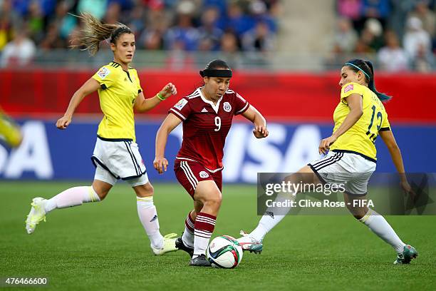 Charlyn Corral of Mexico is tracked by Angela Clavijo of Colombia during the FIFA Women's World Cup 2015 Group F match between Colombia and Mexico at...