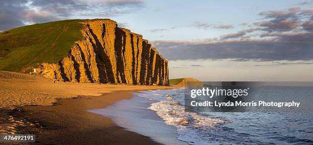 west bay dorset - cliff and beach view at sunset - dorset photos et images de collection