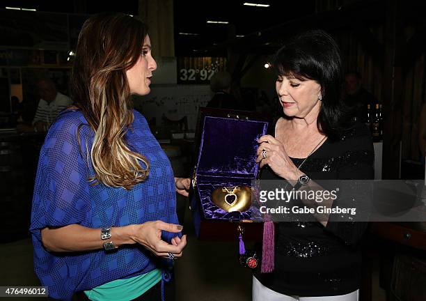 Author Taya Kyle is presented with a purple heart designed purse by designer Kathrine Baumann during the Licensing Expo 2015 at the Mandalay Bay...