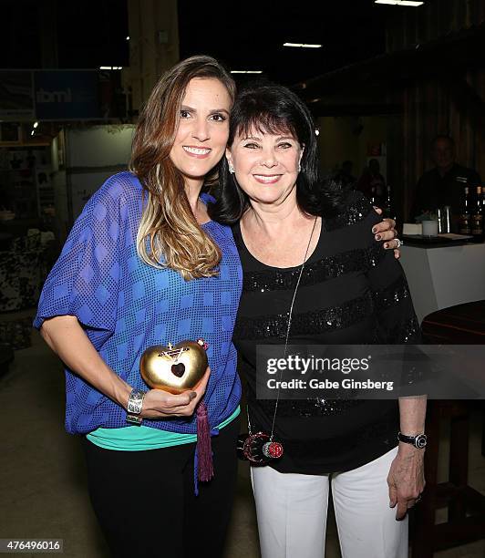 Author Taya Kyle is presented with a purple heart designed purse by designer Kathrine Baumann during the Licensing Expo 2015 at the Mandalay Bay...