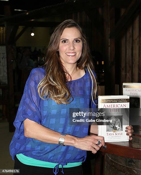 Author Taya Kyle holds up her book "American Wife: Love, War, Faith, and Renewal" during the Licensing Expo 2015 at the Mandalay Bay Convention...