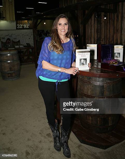 Author Taya Kyle holds up her book "American Wife: Love, War, Faith, and Renewal" during the Licensing Expo 2015 at the Mandalay Bay Convention...