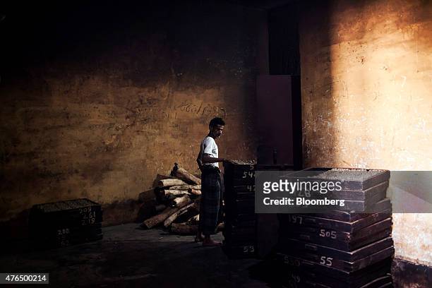An employee inspects trays of roasted bidi cigarettes at the Sarkar Bidi Factory in Kannauj, Uttar Pradesh, India, on Wednesday, June 3, 2015....