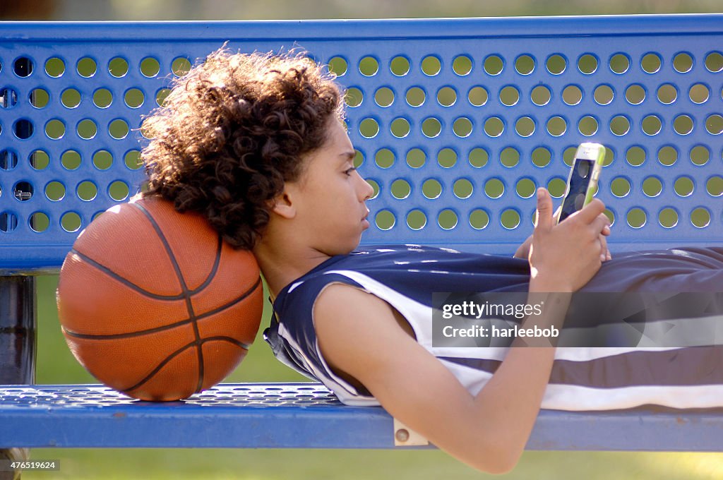 African American boy texting on a mobile phone.
