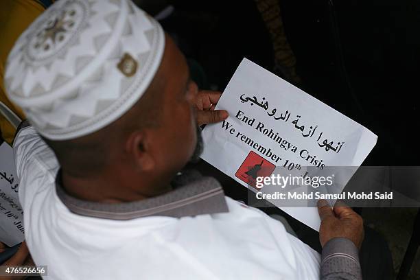 Muslim Rohingyas living in Malaysia holds the poster during a day of commemoration to remember the 2012 Rohingya genocide on June 10, 2015 in...