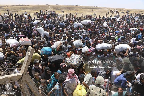 Syrians fleeing the clashes in Rasulayn region of Syria, cross into Turkey from the borderline in Akcakale district of Sanliurfa on June 10, 2015....