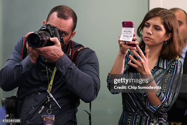 House Republican staffer holds an iPhone with the message 'Smile and say hi! We're live on Periscope! @HouseGOP' during a news conference following...