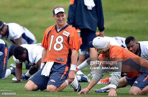 Denver Broncos quarterback Peyton Manning talks with Denver Broncos quarterback Zac Dysert during the stretching period of mini camp June 10, 2015 at...