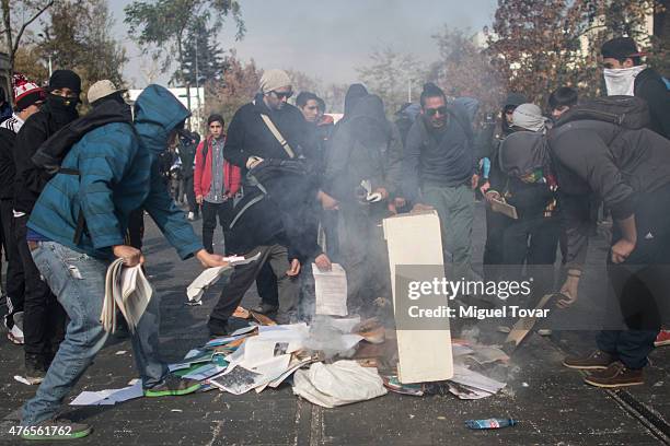 Demonstrators burn notebooks and papers during a march to protest against the government and police action that injured a fellow student last mont in...
