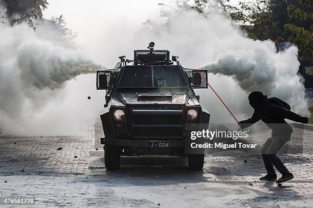 Masked protester runs from teargas thrown by police during a march to protest against the government and police action that injured a fellow student...