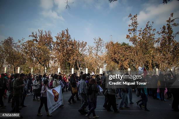 Protesters and students march to protest against the government and police action that injured a fellow student last mont in Santiago, one of the...