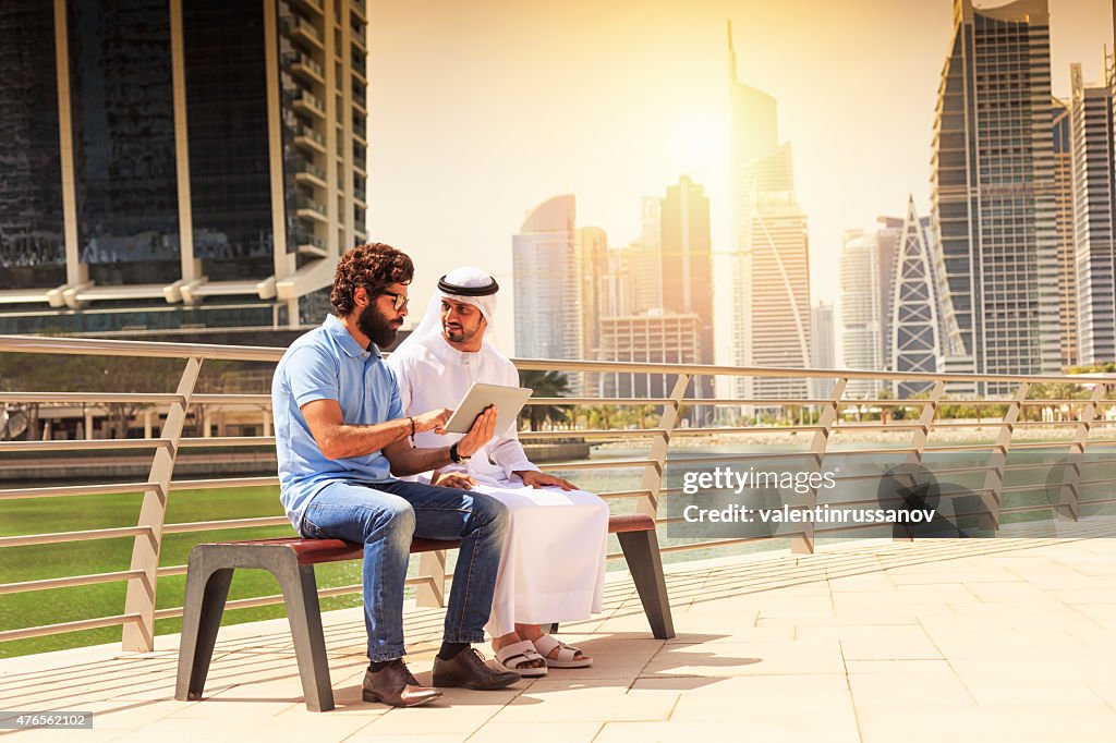 Dubai - Young mens using digital tablet in the city