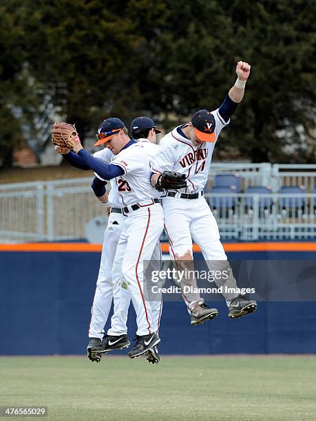 Outfielders Derek Fisher, Brandon Downes and Joe McCarthy of the University of Virginia Cavaliers leep high in the air to celebrate a victury after a...