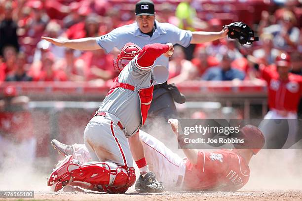 Todd Frazier of the Cincinnati Reds slides home with a run in the seventh inning ahead of the tag by Cameron Rupp of the Philadelphia Phillies during...