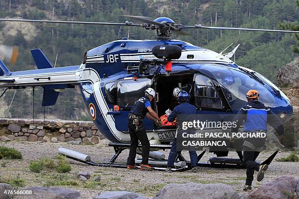 Gendarmes take out of a gendarmerie's helicopter the body of a tourist killed in the GR 20 hiking trail on June 10 near Asco in the French...