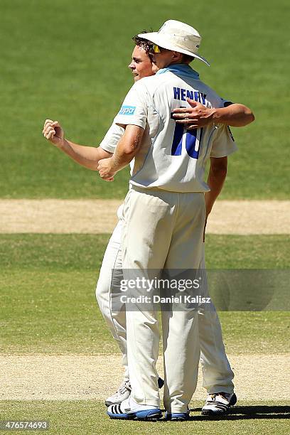 Stephen O'Keefe of the Blues celebrates the wicket of Callum Feguson of the Redbacks with his team mate Scott Henry of the Blues during day two of...