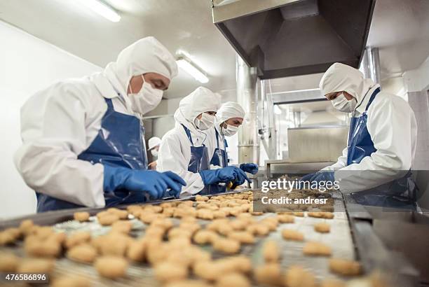 menschen arbeiten in einem food factory - lebensmittelindustrie stock-fotos und bilder