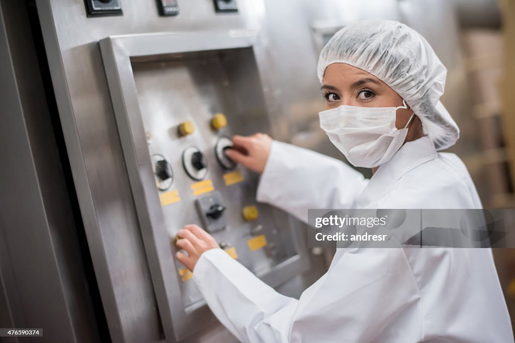 Mulher utilizar máquinas em uma fábrica de alimentos